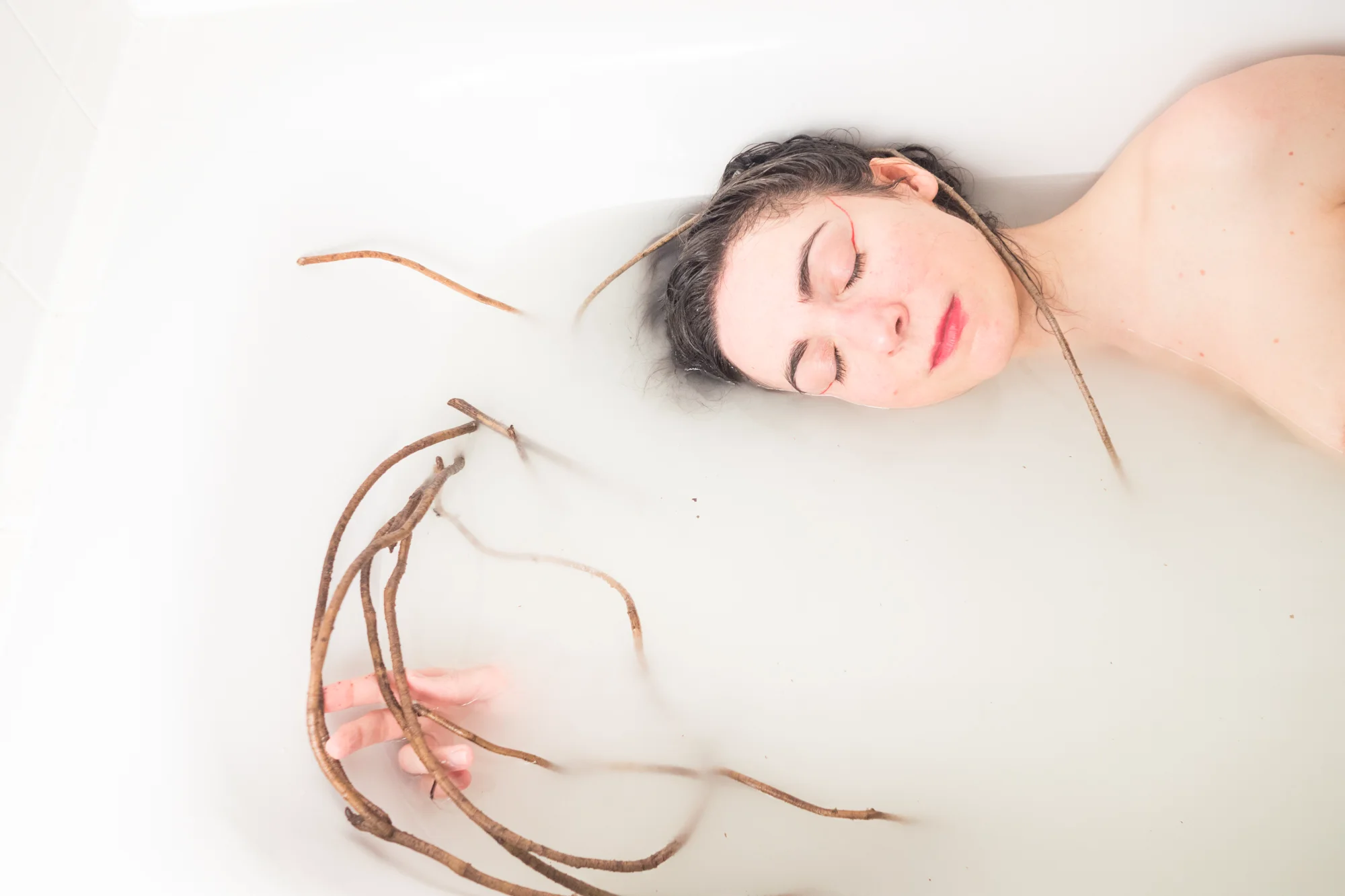 The artist taking a last performative bath before shaving her hair for the artoject Hlymia